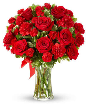 Floral arrangement in Arizona featuring red roses, red carnations, red mini carnations, and a decorative red ribbon, florist delivered in a clear glass vase.