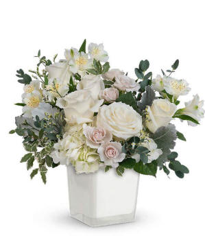 A serene arrangement featuring white hydrangea, white roses, white spray roses, white alstroemeria, white limonium, and floral greens, all elegantly presented in a white cube. This all-white display offers a timeless and peaceful touch to any occasion. Ready to be delivered to Illinois
